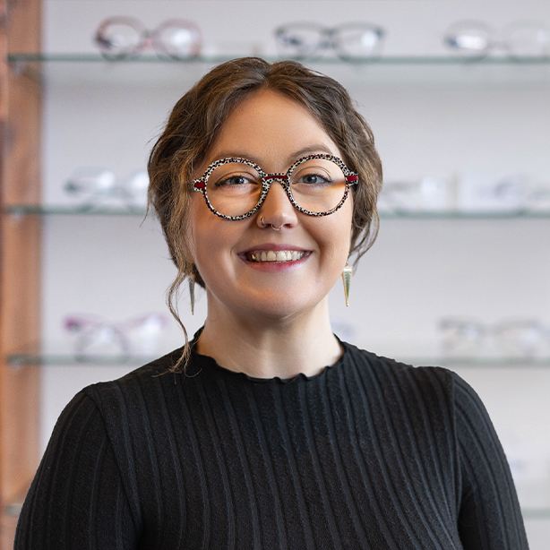 Female optical staff member smiling inside eyewear showroom